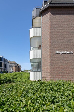Ein modernes Gebäude mit Backsteinfassade und einem Glasbalkon.
