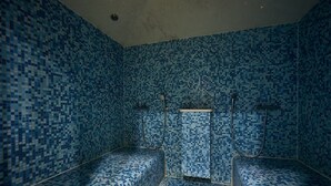 A room with blue mosaic tile walls and floor, two beds, a shower area, and a small window. - Sea View Houlgate Apartment for 4 (Houlgate)