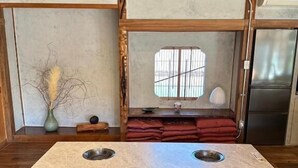 Una cocina con isla central, suelo de madera y ventana con persianas.