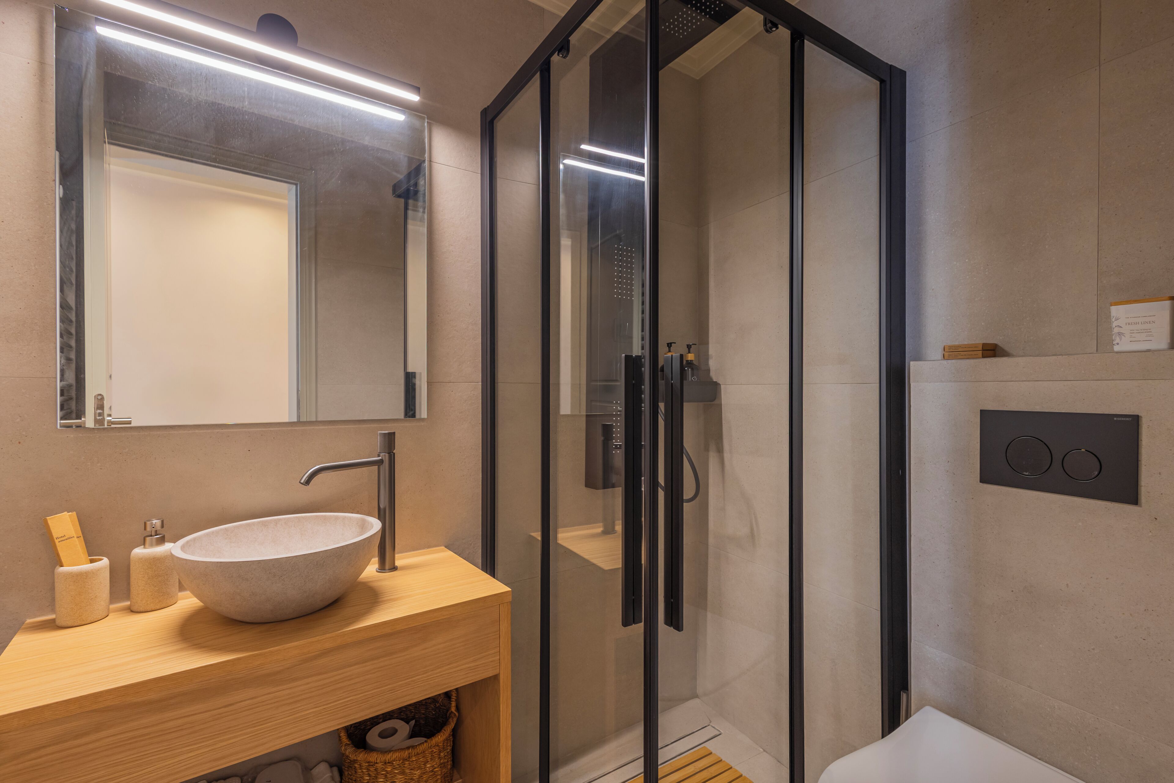 Une salle de bain moderne avec un grand lavabo sur pied, une douche à parois de verre et un meuble-lavabo en bois.