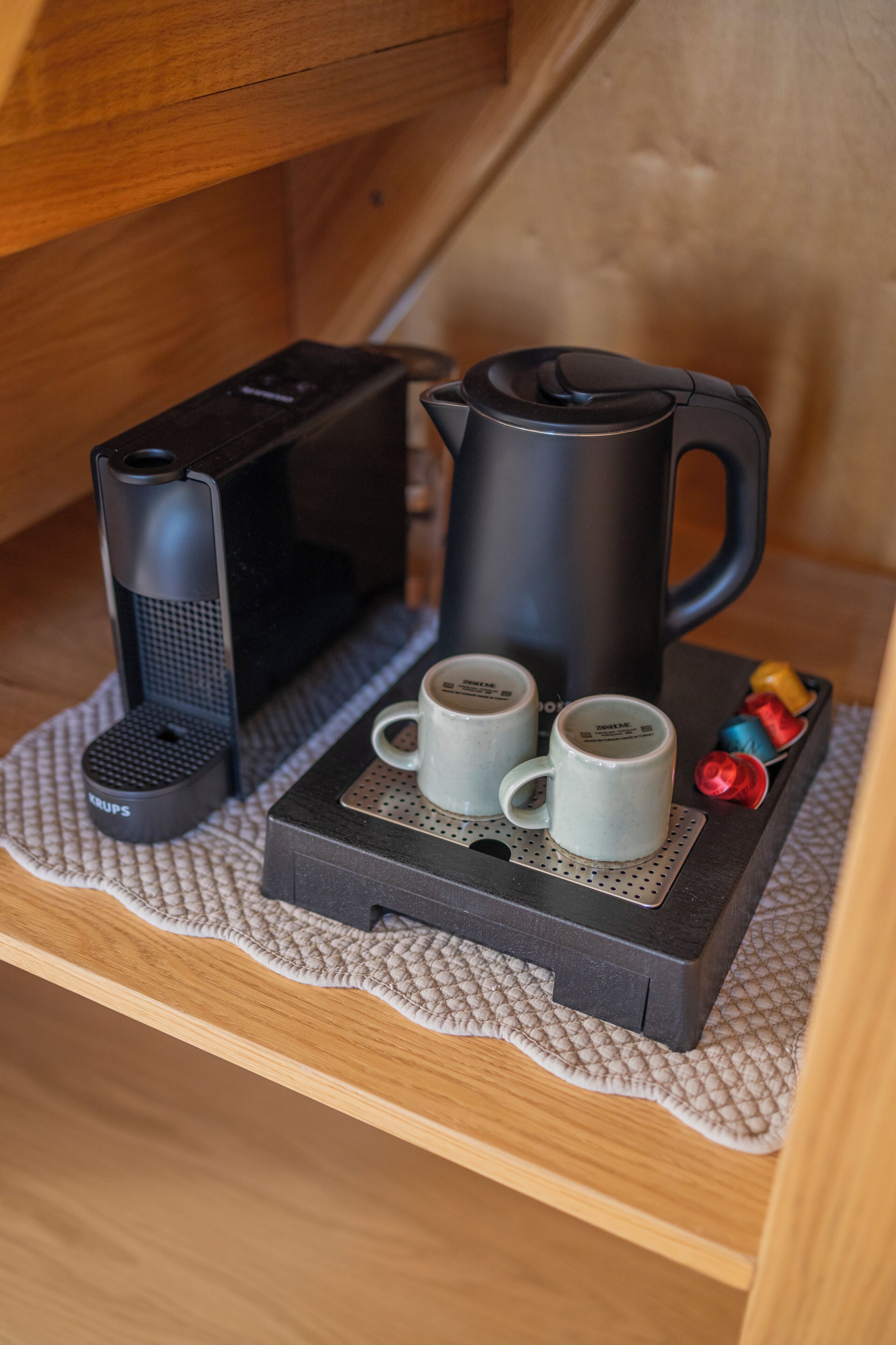 Una cafetera, dos tazas y una tetera sobre una bandeja.