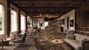 Una habitación amplia con techo alto, vigas de madera y una variedad de opciones de asientos, incluyendo sofás y sillones.