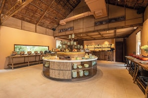 A spacious room with a central island, a bar area, and a large window providing natural light. - Alagon Ecolodge Nam Cat Tien (Nam Cat Tien)
