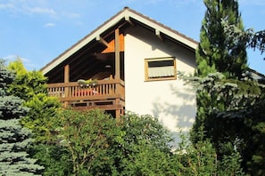 A chalet with a wooden balcony, surrounded by dense greenery. - Holiday apartment in Lug with swimming pool (Lug)