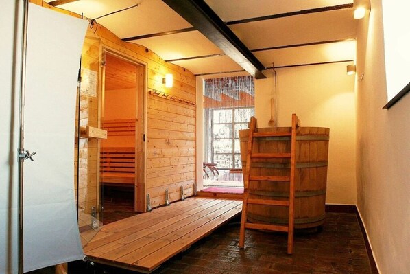 A wooden interior with a wooden door, a wooden bench, a wooden ladder, and a window with a view. - The yellow holiday home (Irmenach)