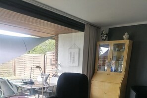 Una habitación con una mesa de comedor, sillas, un armario y una ventana.