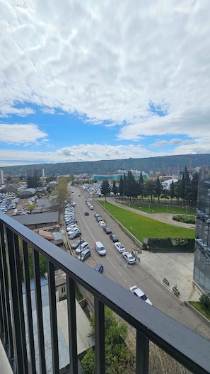 A cityscape with a road, parked cars, and buildings. - Cozy 1-bedroom apartment in enchanting T'bilisi with (T'bilisi)