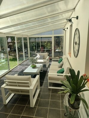 A conservatory with a glass ceiling, white furniture, and a potted plant. - Beautiful, quiet, air-conditioned villa with swimming pool (Poulx)