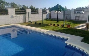 A swimming pool with a fenced area, a small garden, and a gazebo. - Cuervi house with private pool in Conil. (Conil De La Frontera)
