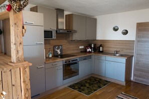 Eine moderne Küche mit Mikrowelle, Herd, Backofen und Spüle.