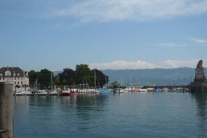 Un puerto deportivo con barcos amarrados, una estatua y un edificio al fondo.