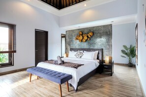 Ein modernes Schlafzimmer mit einem großen Bett, einer Bank, einem Wandbild und einem Blumentopf.