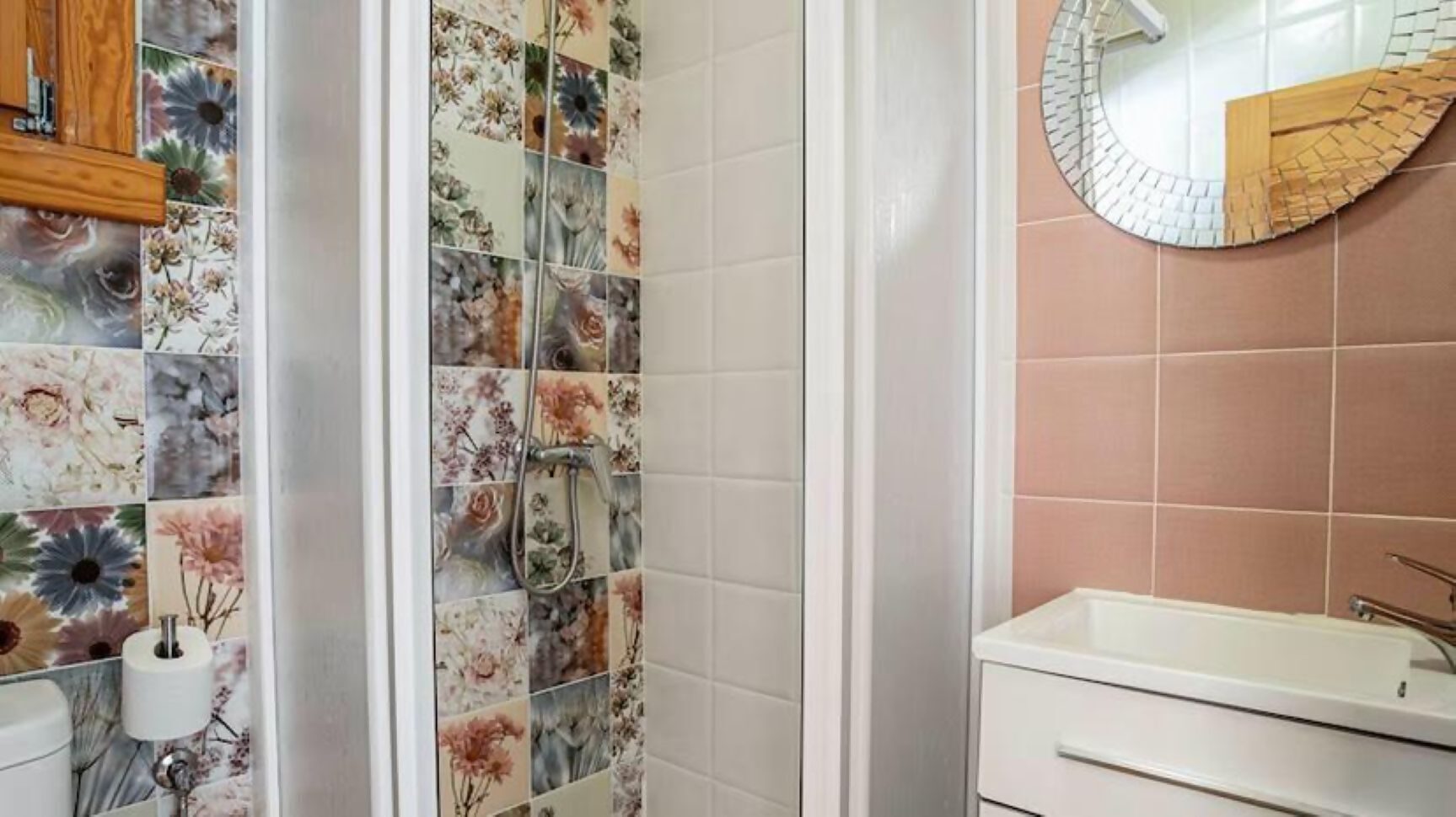 Ein Badezimmer mit Dusche, Waschbecken und Spiegel.