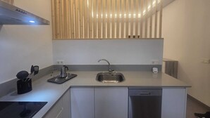 Una cucina moderna con lavello in acciaio inossidabile, forno integrato e lavastoviglie.