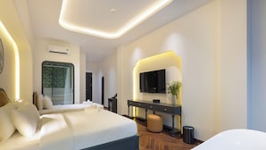 Habitación de hotel moderna con una cama grande, un televisor, una mesita consola y un baño con bañera blanca.