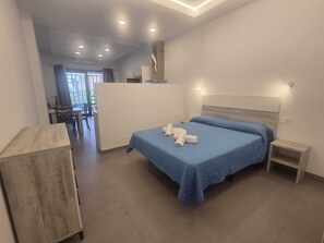 Een moderne hotelkamer met een groot bed, een bureau en uitzicht op het omliggende landschap.
