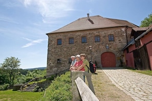 Ein Steinhaus mit roter Tür und einer Treppe, die davor hinaufführt.