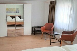 A bedroom with a bed, a wardrobe, a desk, two chairs, and a window with curtains. - 2 in the Lavender House (Endingen-Amoltern am Kaiserstuhl)