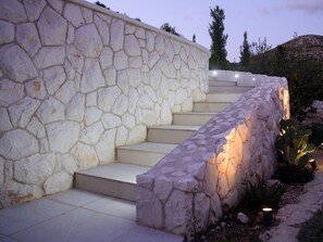 A stone staircase with steps leading up to a landing, surrounded by vegetation. - Vacation home Nerium by Interhome (Trogir/Vranjica)