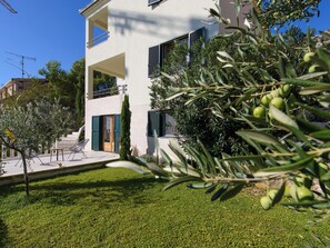 A modern two-story building with a balcony, a door with shutters, and a well-maintained lawn. - Vacation home Nerium by Interhome (Trogir/Vranjica)