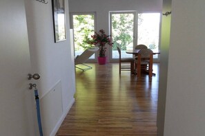 A hallway with wooden flooring, a potted plant, and two chairs by a window. - Holiday apartment with 1 bedroom (Tübingen)