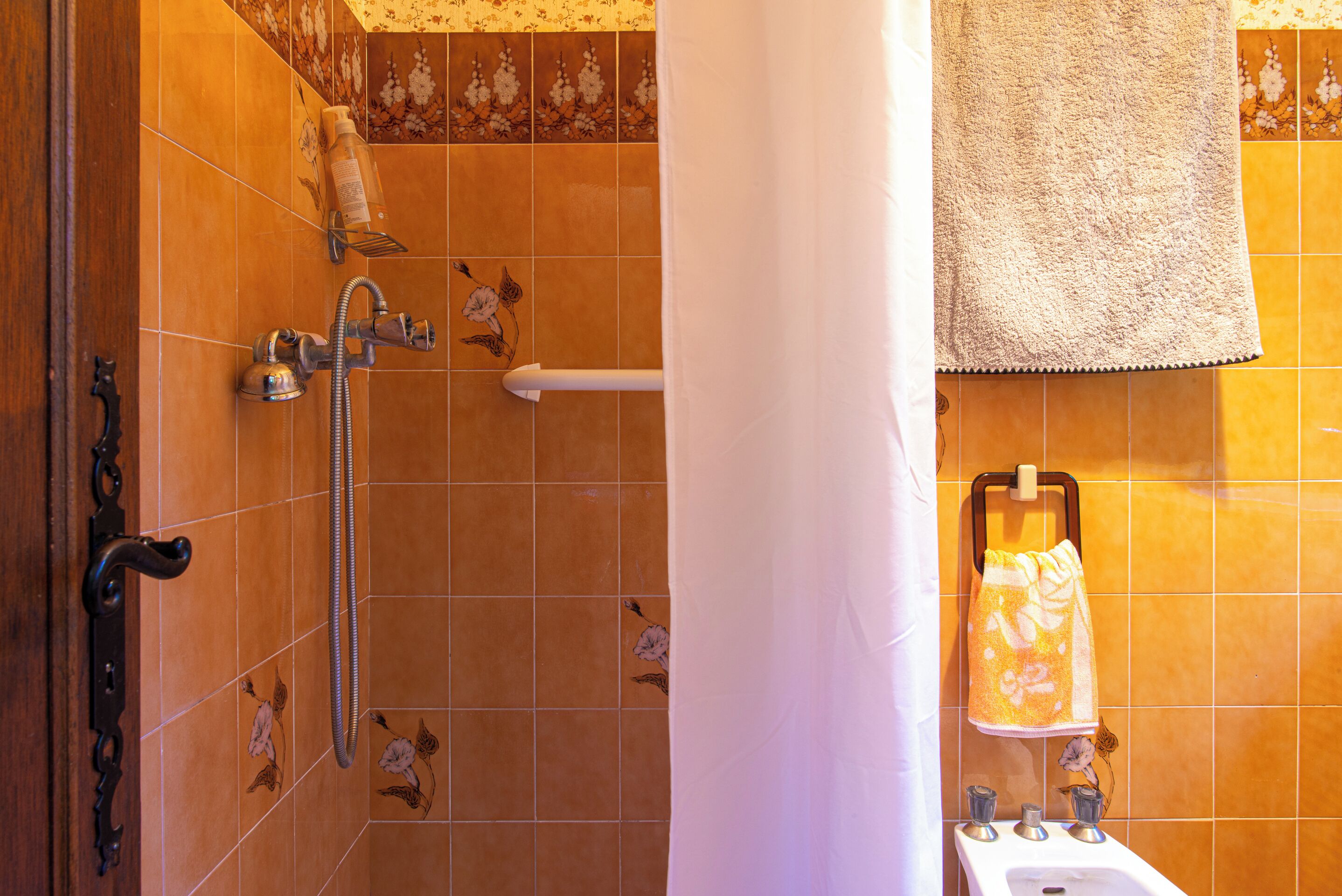 A bathroom with a shower, a towel rack, and a sink.