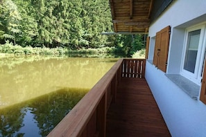 Ein Holzdeck mit Blick auf einen See und einen Wald.