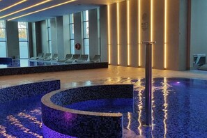 A modern indoor pool area with seating and a central water feature. - Holiday apartment with 2 bedrooms (Dziwnowek)