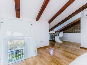 A modern interior with wooden beams, a glass door leading to a balcony, and a white chair. - Apartment Nerium by Interhome (Trogir)