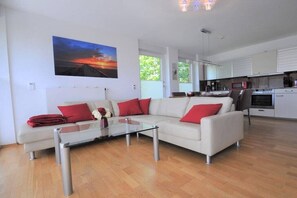 Ein modernes Wohnzimmer mit einer Couch, einem Couchtisch und einem Gemälde an der Wand.