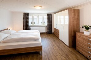Ein Hotelzimmer mit Bett, Kleiderschrank und einem Vorhangfenster.