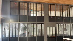 Un edificio moderno con amplios ventanales, piso de baldosas y una cocina a la vista.