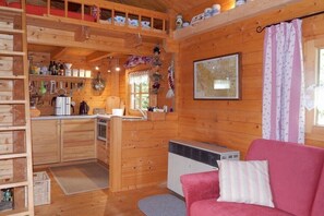 Ein Holzhütten-Innenraum mit einer Küche, einem Sofa und einer Karte an der Wand.