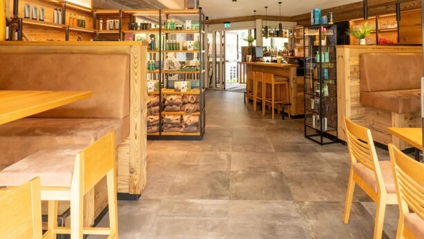 A modern interior with wooden furniture, shelves with products, and a bar area.