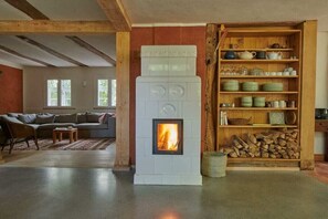 A living room with a fireplace, a sofa, a coffee table, and a bookshelf with dishes. - Old Elbe boatman's house (Unbesandten)