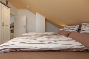 Ein Schlafzimmer mit einem Bett, Kissen und einem Kleiderschrank.