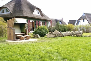 Thatched-roof cottages with outdoor seating and a thatched roof. - Holiday home in Rügen with 2 bedrooms (putgarten)