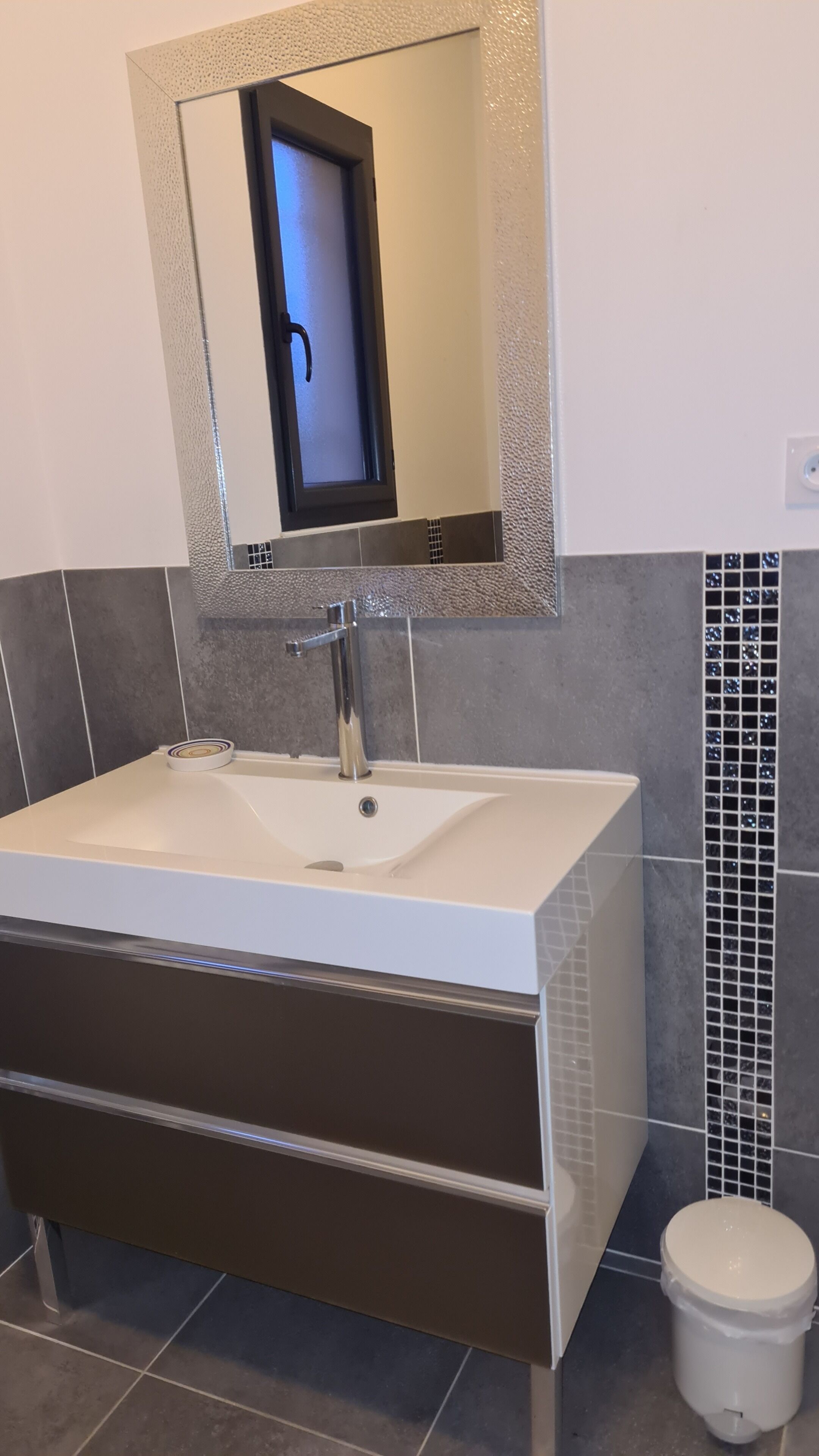 A bathroom with a white sink, a mirror, and a toilet.