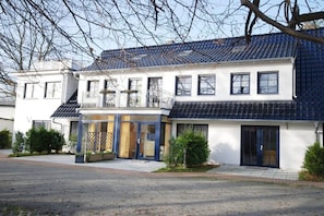 A two-story house with a balcony, large windows, and a paved driveway. - Holiday home in Binz with swimming pool (Binz)