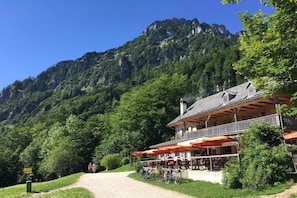 Eine Berglodge mit Außenbestuhlung, Fahrrädern und Bergblick.