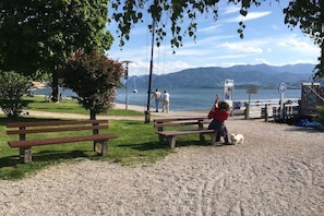 Ein Park mit Bänken, einem Hund und Blick auf einen See.