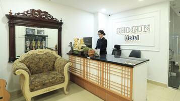 A reception desk with a mirror, trophies, and a sofa.