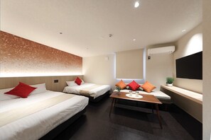 Una habitación de hotel con dos camas, una mesita, un televisor y una ventana.