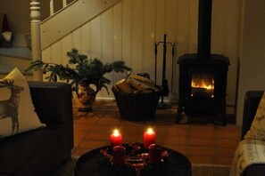Ein gemütliches Wohnzimmer mit Kamin, einer Treppe und einem Weihnachtsbaum.