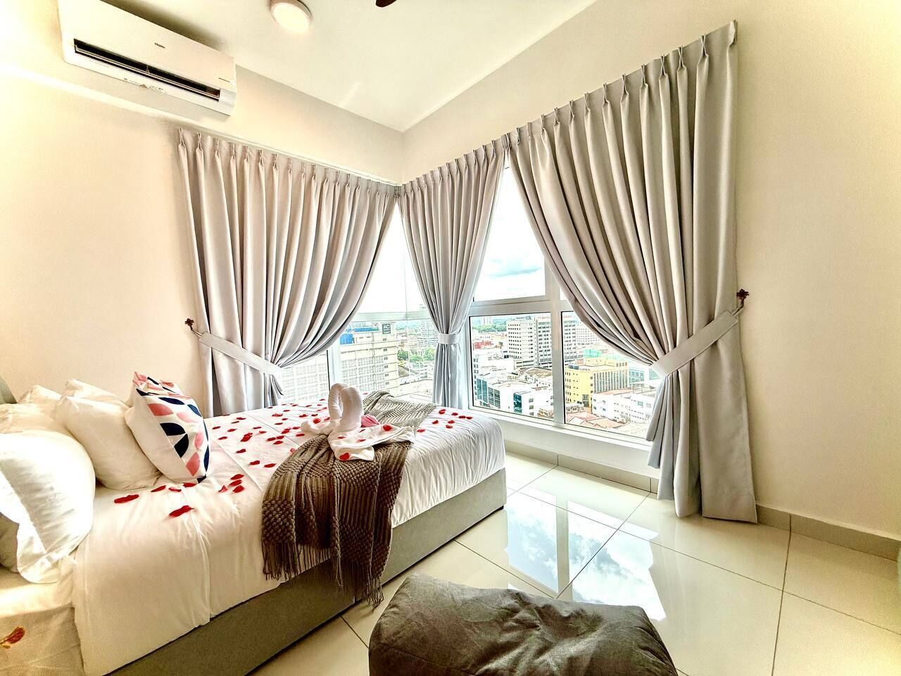 Une chambre moderne avec un lit, des rideaux et une vue sur la ville.
