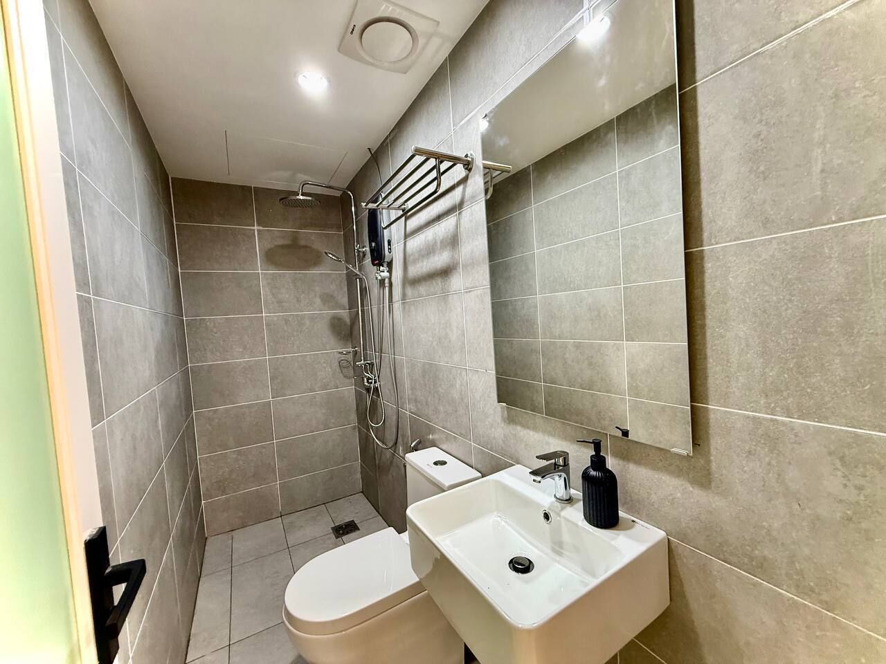 Une petite salle de bain comprenant des toilettes, un lavabo et une douche.