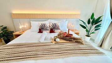 A neatly made bed with a decorative headboard, a bedside table with a lamp, and a potted plant.