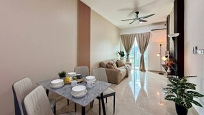 Un soggiorno moderno con zona pranzo, una ventola a soffitto e un'ampia finestra con tende.