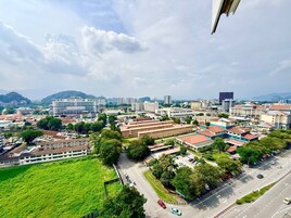 A cityscape with a mix of modern and traditional buildings, a green park area, and a road with vehicles.