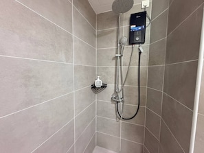 A shower with a handheld showerhead, a wall-mounted control panel, and a soap dispenser on a shelf. - OliveSky Suites Ipoh by Grab A Stay  (Ipoh)